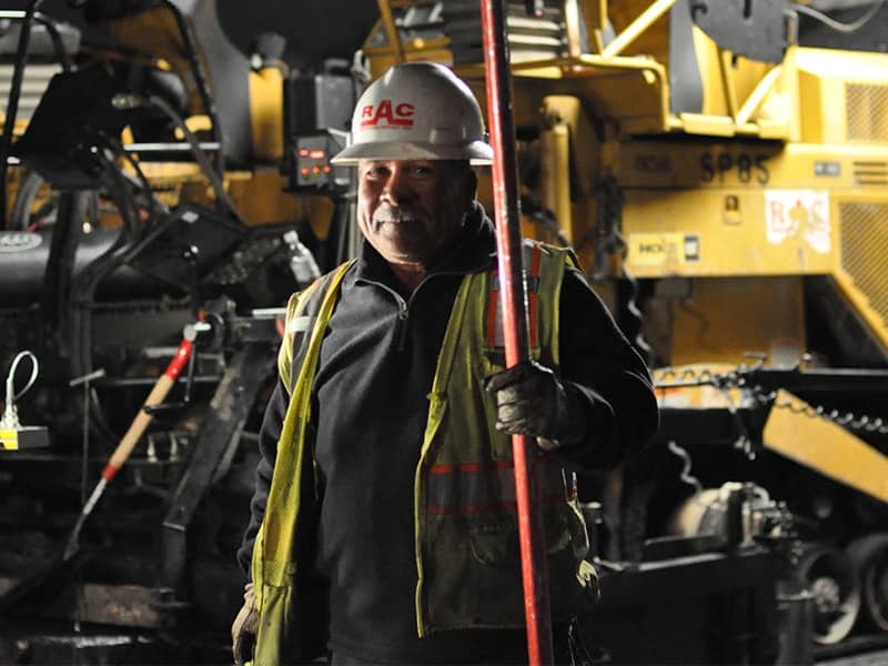 RAC field personnel in front of asphalt paving machine